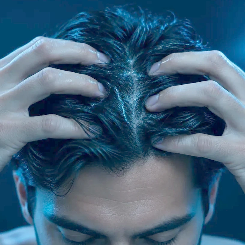 Fingertips massaging the solution into the scalp